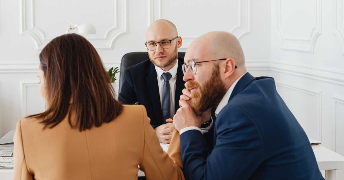 Lawyers consulting with clients in a modern office setting, discussing legal matters.